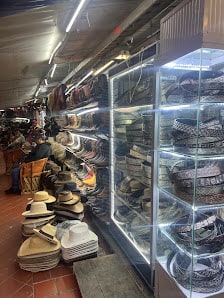 Vista del pasillo del mercado con las vitrinas del local a la derecha y más artículos de piel a lo largo